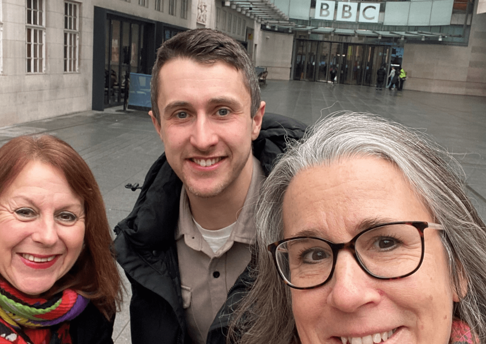 Three people standing outside BBC Broadcasting House in London